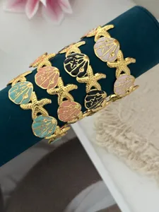 Detailaufnahme der bunten Emaille-Armreifen mit Seesternen und Muscheln im Ozean-Stil.