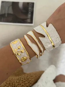 Gedetailleerd overzicht van wit geëmailleerde armbanden met fruit- en bladmotieven