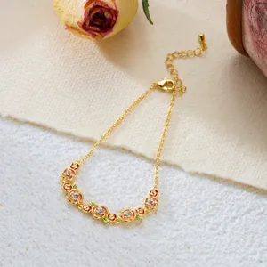 Detailed view of a vintage gold-toned bracelet with enamel rose flower and crystal charms.