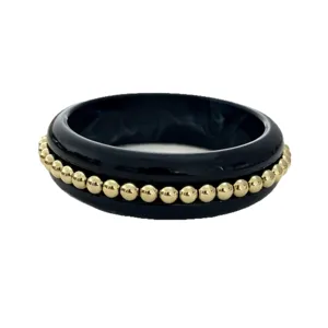 Bracciale rigido vintage in resina nera con perle dorate, elegante gioiello retrò.