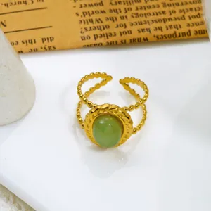 Macro vista di un anello vintage dorato regolabile con pietra naturale verde ovale