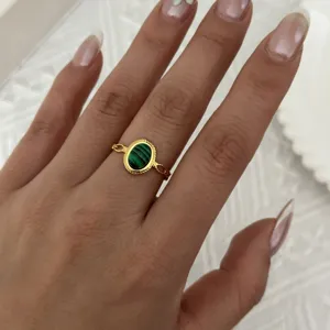 Dettaglio di un anello regolabile vintage in oro con pietra malachite verde