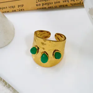 Primo piano di anello vintage regolabile in oro con tre pietre naturali verdi incastonate