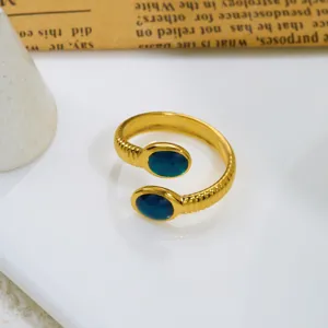 Vista macro dettagliata di un anello vintage dorato regolabile con due pietre pavone blu
