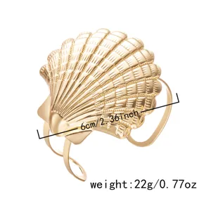 Dettaglio del design a conchiglia dorata su bracciale da braccio regolabile stile oceano.
