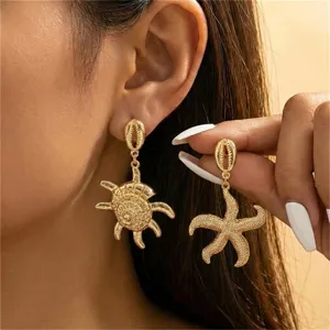 Nahaufnahme goldener Ohrringe im Ozean-Stil mit Seestern- und Muscheldesign