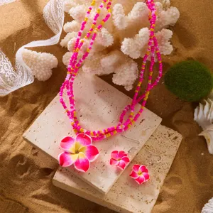 Nahaufnahme des tropischen Plumeria-Blüten-Halsketten- und Ohrring-Schmucksets aus Ton