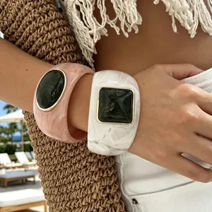 Dettaglio di bracciali rigidi in resina effetto agata per uno stile da spiaggia chic