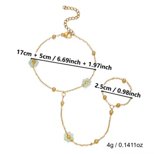 Dettaglio di un bracciale da dito dorato con fiori verdi e misure del prodotto.