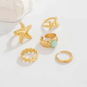Set van gouden verstelbare teenringen in maritiem thema met zeester en groene steen