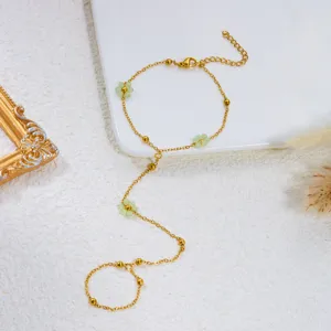 Vista dettagliata di un'elegante catena da mano dorata con fiori verdi e perline