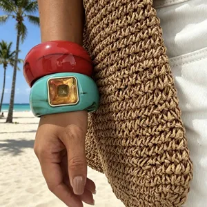 Dettaglio di bracciali larghi in resina con texture agata per uno stile da spiaggia