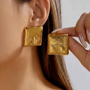 Close-up detail of vintage chunky gold textured rectangular stud earrings for women
