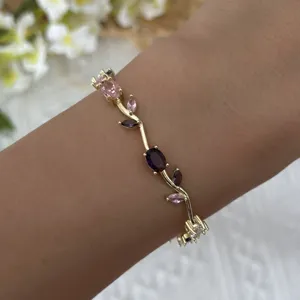 Close-up of gold vine bracelet with pink and purple marquise crystals on wrist