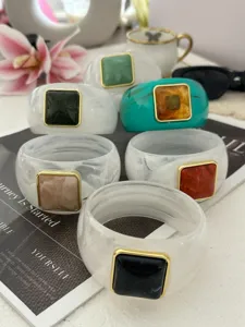 Eleganti bracciali larghi in acrilico con inserti quadrati in finta agata stile resort.
