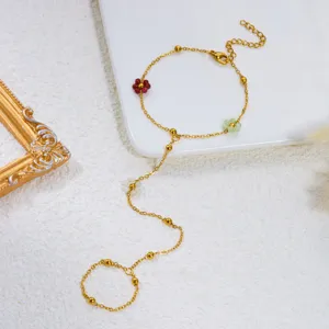 Vista dettagliata del bracciale da dito a catena d'oro con ciondoli a fiori smaltati