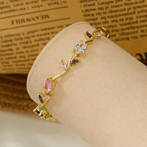 Detailed macro view of a gold-plated vine bracelet with colorful gemstones on a stand