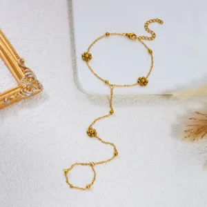 Dettaglio della delicata catena dorata e dei fiori di perline di questo anello bracciale