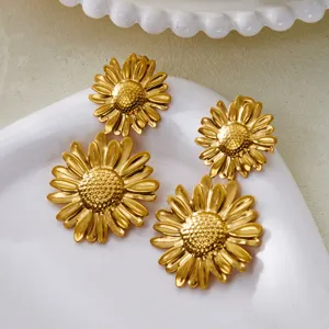 Detail shot of vintage gold stainless steel daisy flower stud earrings on ceramic tray