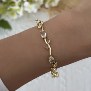 Close-up detail of a gold-plated vine bracelet featuring elegant clear leaf-shaped crystals
