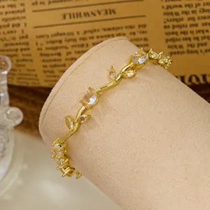 Detail shot of a gold-plated vine bracelet featuring leaf design and clear crystals.