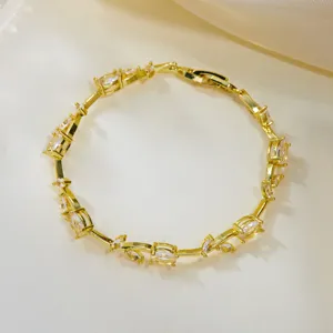 Detail view of an elegant gold vine leaf bracelet with sparkling champagne crystals.