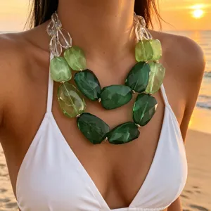 Detail van groene harsketting met onregelmatige kralen op het strand bij zonsondergang