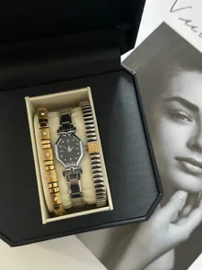 Close-up of octagonal black dial watch and rhinestone bracelets in a black gift box.