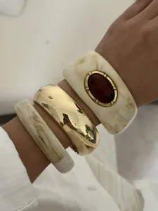 Nahaufnahme von Vintage-Harzarmreifen mit Marmorierung und goldenem Armreif