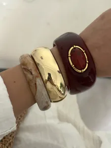 Nahaufnahme der Retro-Harzarmbänder mit Marmormuster und rotem Steininlay im Vintage-Stil