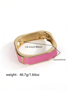 Detail view of a pink enamel bangle bracelet with gold plating and size labels