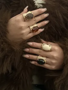 Detailed shot of chunky gold-tone hip-hop rings with colorful resin oval stones