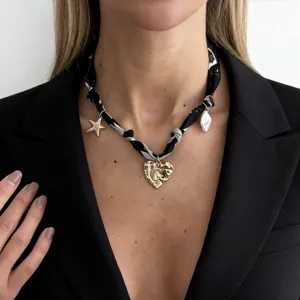 Close-up of black and white silk scarf necklace with lava heart and starfish charms.