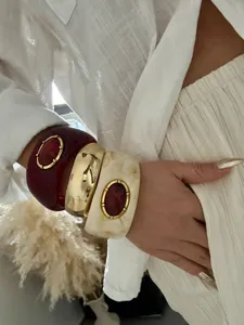 Detailansicht von geschichteten Retro-Resin-Armreifen mit goldenen Metallakzenten