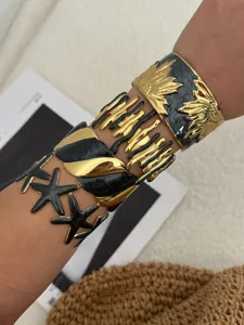 Detaillierte Ansicht von vier eleganten gold-schwarzen Edelstahl-Armreifen-Sets.
