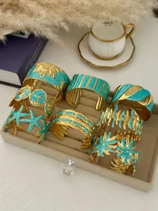 Detailed shot of assorted retro gilt enamel open bangles in a velvet tray