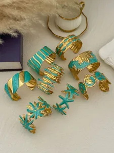 Collection of vintage gold-plated open bangles featuring turquoise enamel and floral designs
