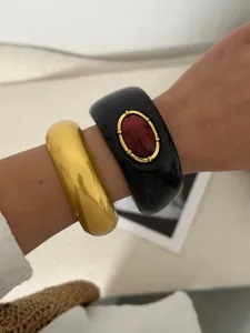 Bracelets joncs bohèmes épais en résine portés au poignet pour un style ethnique chic.