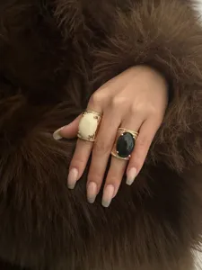 Close-up view of vintage gold chunky rings featuring black and white oval resin stones
