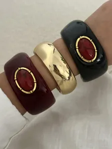 Vintage Harz- und Metall-Armreifen mit rotem Kunststein-Inlay und goldener Verzierung