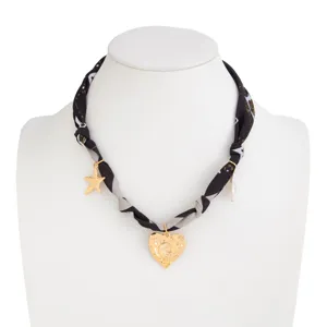 Vintage fabric scarf necklace with gold lava heart, star charm, and pearl detail.