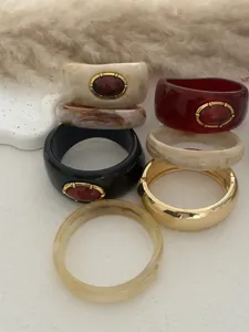 Detailaufnahme von Vintage-Resin-Armreifen mit Marmorierung und rotem Schmuckstein