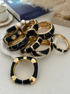 Detailweergave van diverse vintage emaille gouden armbanden met zwarte oliepatronen