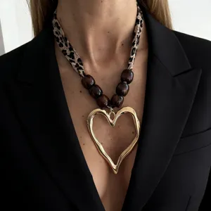 Close-up of a leopard print silk scarf necklace featuring a large golden molten heart pendant.