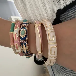 Stylish colorful enamel bamboo style and geometric pattern bangles stacked on wrist