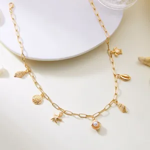 Macro view of a gold-toned necklace featuring starfish, seashell and turtle charms.