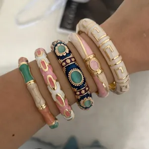 Stackable colorful enamel bamboo bangles and geometric drip glaze bracelet set on wrist.