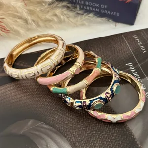 Colorful enamel bamboo-style bangles with geometric and floral patterns in gold finish