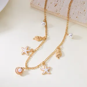 Close-up macro detail of gold beach vacation necklace with starfish and pearl charms