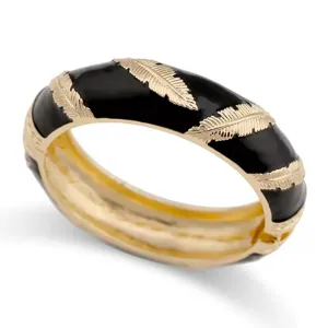 Detailaufnahme eines breiten schwarzen Emaille-Armreifs mit goldenen Federmustern